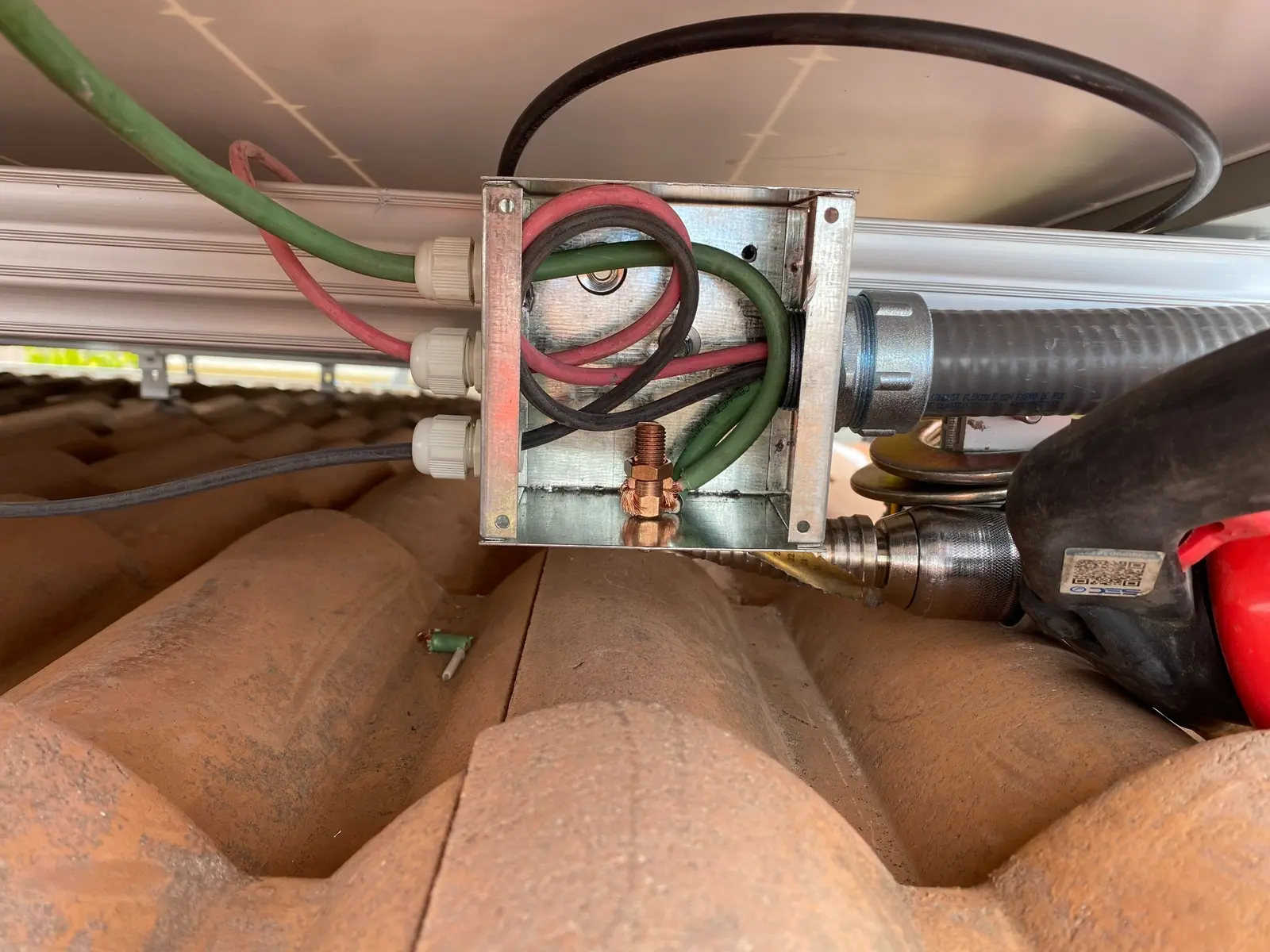 Interior de caja de paso durante el tendido y ordenamiento del cableado fotovoltaico