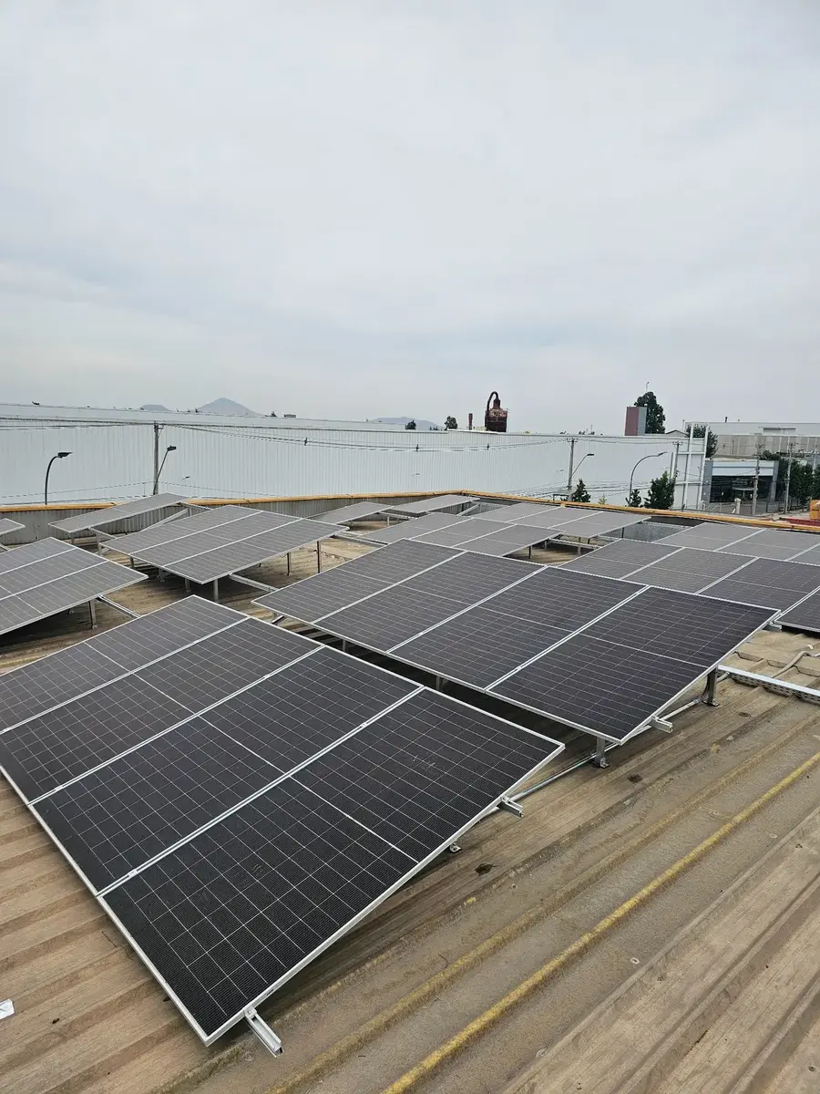 Filas de módulos fotovoltaicos instaladas sobre cubierta industrial
